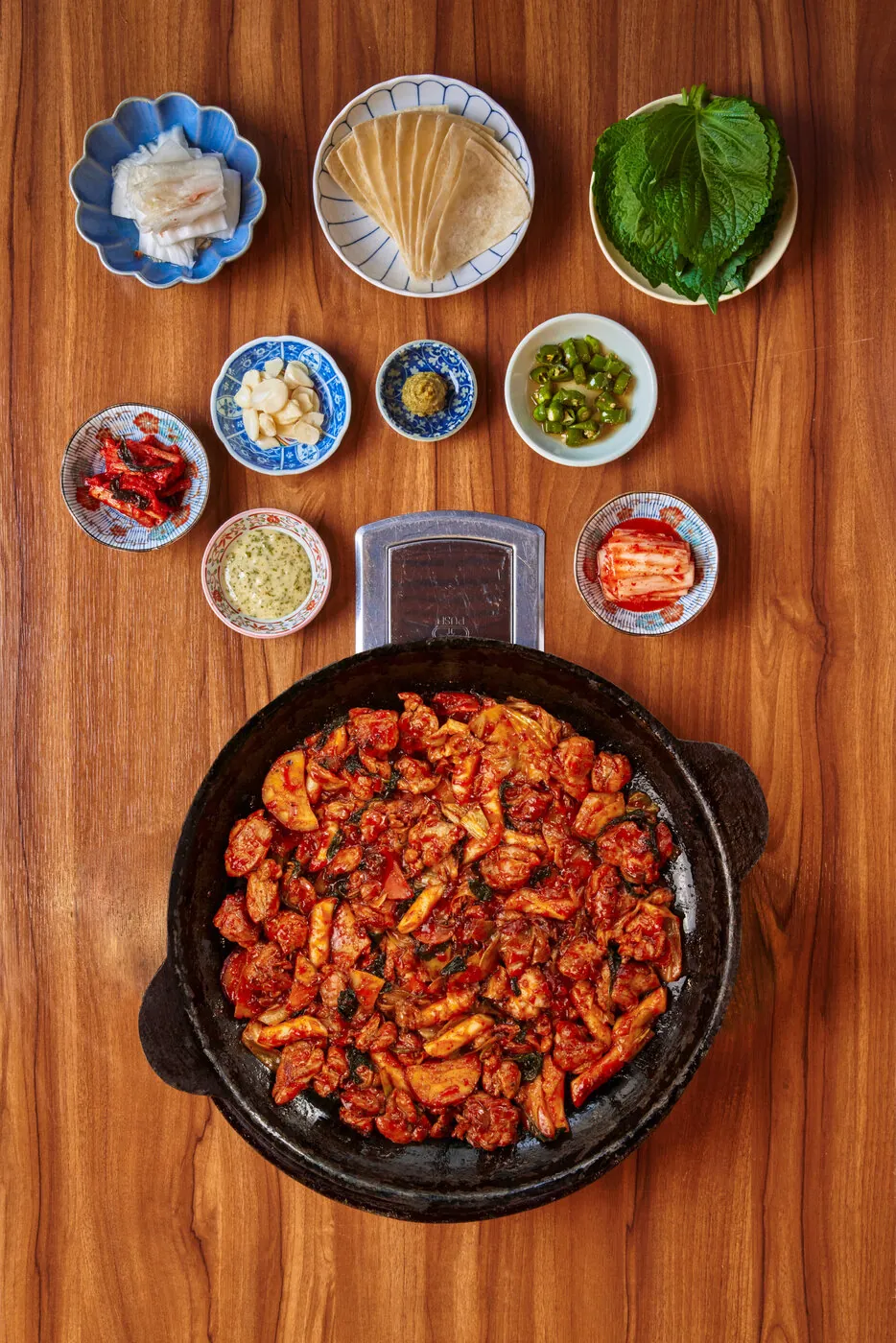 무쇠 철판에 담긴 직화 닭갈비와 반찬을 위에서 본 모습